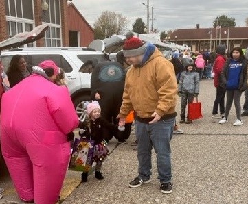 Costumed children get treats from Wilton Public Library staff members.